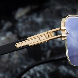 Detailed close-up of golden metal hinges and blue lenses on semi-rimless sunglasses