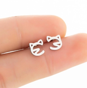 Close-up of minimalist cat-shaped stainless steel stud earrings held for size reference