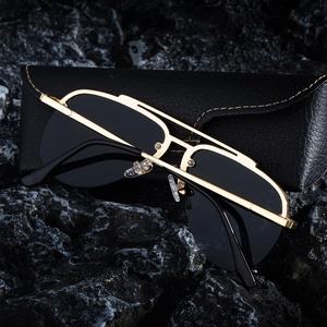 Detail of aviator sunglasses with gold metal double bridge on dark mineral stone