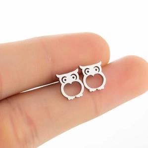 Polished stainless steel owl stud earrings shown on finger for size reference