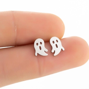 Close-up of small silver ghost stud earrings held on a fingertip for size reference