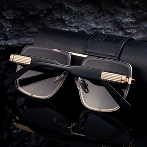 Detail of luxury square sunglasses with gold metal bridge on premium black leather case