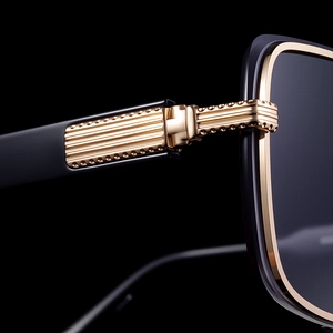 Macro shot of high-quality gold metal hinge with vertical stripes on square sunglasses