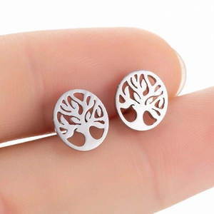 Detailed macro view of silver hollow tree of life studs held for size reference