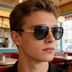 Detail of pilot sunglasses showing black frame, gold double bridge and temple accents