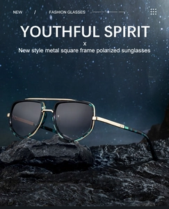 Close-up of metal square polarized sunglasses with teal marble texture on rocky base