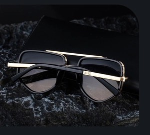 Detail of luxury polarized sunglasses with golden metal bridge and black leather case