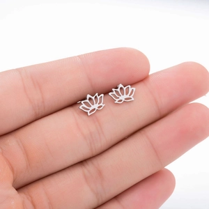 Détail macro de boucles d'oreilles lotus en acier inoxydable argenté portées