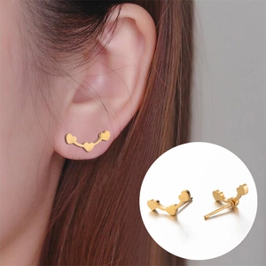 Minimalist triple heart stud earrings in polished gold stainless steel worn by model