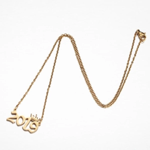Close-up of gold stainless steel necklace with 2019 year pendant and small crown detail