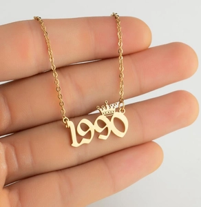 Macro view of gold-plated 1990 crown pendant necklace with fine chain detail