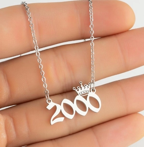 Detailed view of silver crown number 2000 year pendant necklace held in hand
