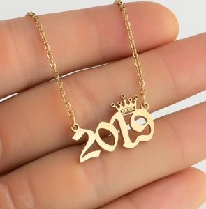 Close-up of gold crown year necklace with 2019 number pendant on a delicate chain
