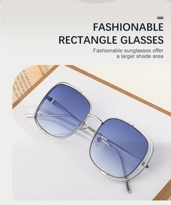 Détail de lunettes de soleil carrées à monture métallique argentée et verres bleu dégradé