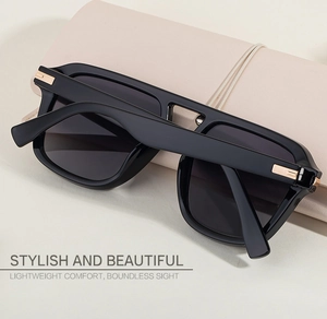 Detail of square black sunglasses with gold metal accents on sleek temples