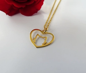 Vue macro du pendentif doré en forme de cœur et chat avec une rose rouge romantique