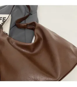 Close-up of the dark brown leather texture and soft finish of the large hobo tote bag
