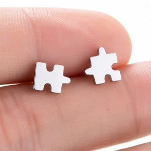 Vue rapprochée de puces d'oreilles puzzle en acier inoxydable poli pour femmes