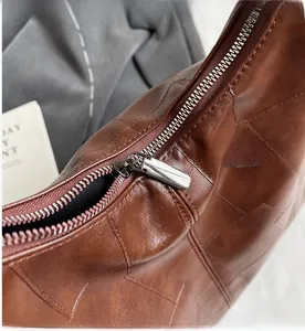 Detail of a smooth silver zipper on a vintage brown textured leather backpack for women