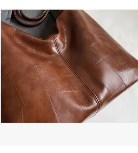 Detail of premium brown leather tote with soft pebble grain texture and neat stitching