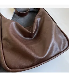 Detailed view of large dark brown tote bag showing the soft vintage leather texture and folds