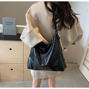 Detailed back view of a large black leather hobo bag with a silver chain and long strap