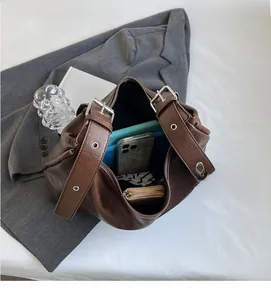 Spacious interior of large brown leather hobo bag showing capacity for phone and wallet