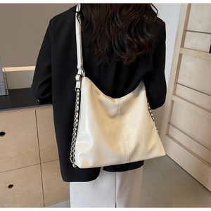 Hobo shoulder bag featuring cream faux leather with geometric quilted pattern and chain strap
