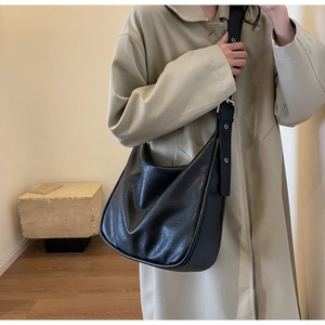 Detail of black large Hobo shoulder bag with silver eyelets on soft PU leather strap