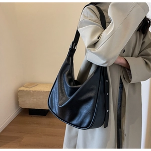 Side view of large black hobo bag with soft leather texture and silver buckle detail
