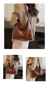 Detail view of brown vintage leather hobo bag with unique stitching and metal chain strap