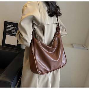 Detailed view of the large brown shoulder bag with a vintage wrinkled texture and silver zipper