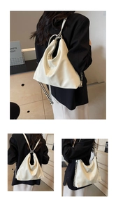 Detail of white crocodile texture bag showing convertible metal chain straps for versatile wear