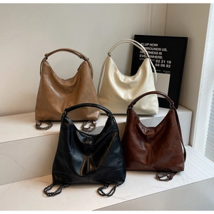 Detail view of large hobo bags in four colors with crocodile texture and metal chain straps