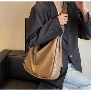 Khaki large capacity hobo bag worn with black blazer for minimalist commute style