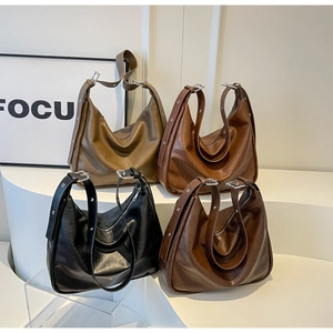 Detail view of four minimalist faux leather hobo bags in assorted autumn colors