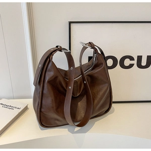 Detail of a dark brown large hobo tote bag with a metal buckle and soft PU leather texture