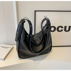 Detail of black pebbled leather hobo bag with silver adjustable buckle on wide strap
