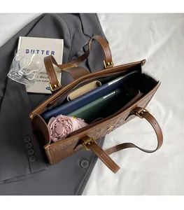 Detail of spacious brown crocodile pattern tote bag interior with multiple compartments