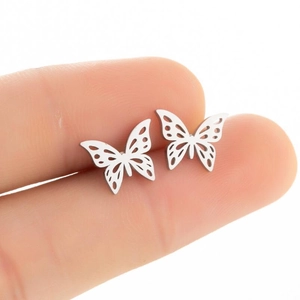 Detailed view of silver butterfly stud earrings with hollow wings held for scale