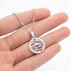 Close-up of circular geometric hollow pendant in silver stainless steel on white background