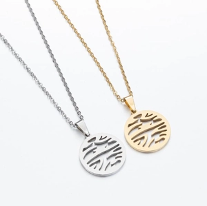 Detail of laser-cut geometric tree of life pendants in polished gold and silver steel