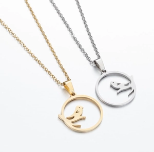 Close-up of gold and silver hollow petal pendants with bird motifs and lobster clasp detail