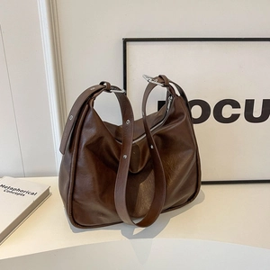Large dark brown tote bag in matte leather with wide strap and silver metal eyelets