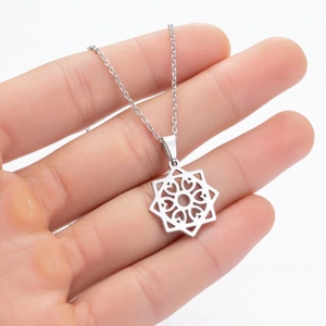 Close-up of geometric star pendant necklace with heart cutout design held by hand