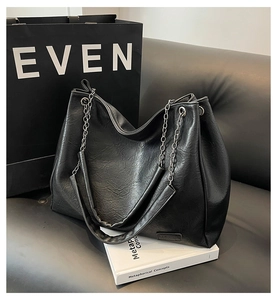 Dettaglio borsa tote in pelle PU nera con catena d'argento ed etichetta fashion