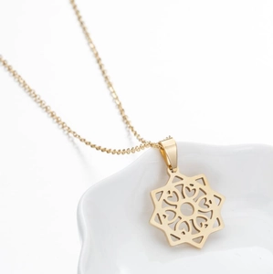 Macro shot of gold-plated octagonal star pendant with intricate heart hollow design