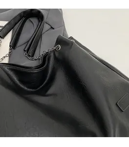 Dettaglio borsa shopper nera con catena d'argento e morbida pelle sintetica al tatto