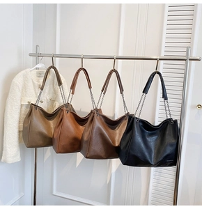 Dettagli di quattro borse tote in pelle colorata con eleganti tracolle a catena