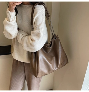 Dettaglio della borsa tote in pelle PU marrone con tracolla a catena e spallina